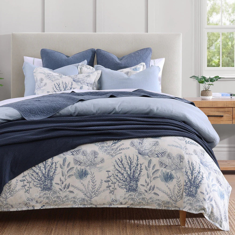 Bed with blue and white floral bedding in a bedroom setting