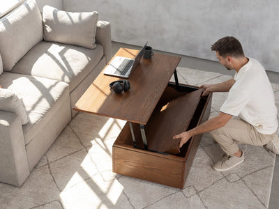 Person using a wooden coffee table with a hidden compartment in a modern living room.