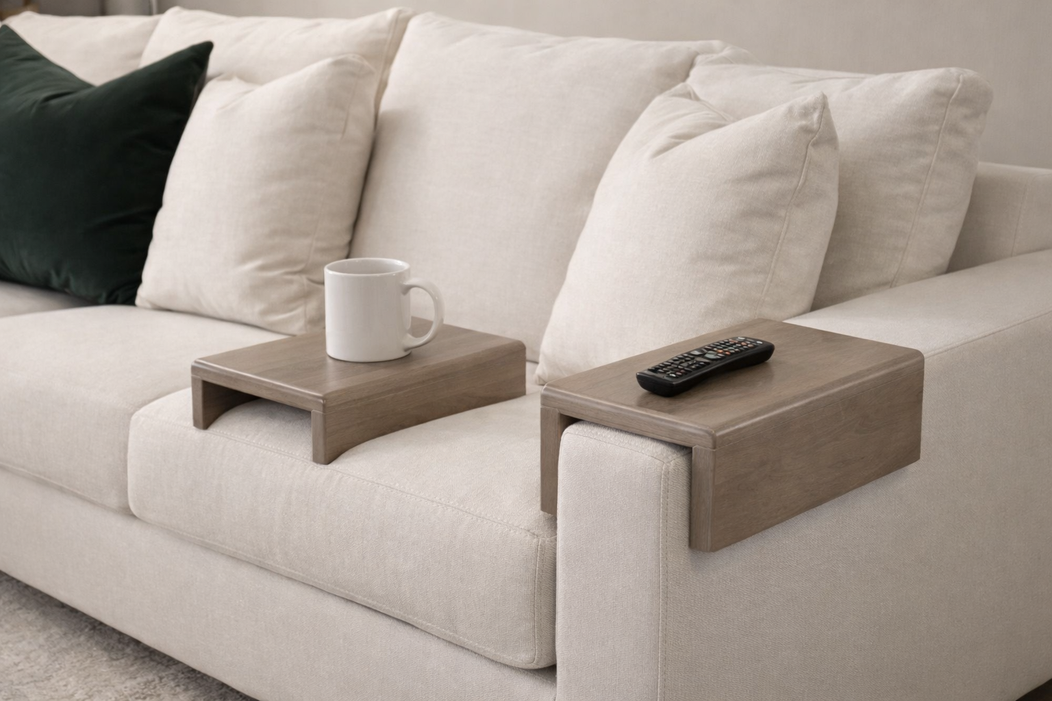 Sofa with wooden side tables holding a cup and remote control.