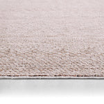 Close-up of a textured beige carpet border on a light gray background