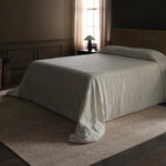 Bed with white bedding in a dimly lit bedroom