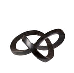 Black metal sculpture of intertwined rings on a white background