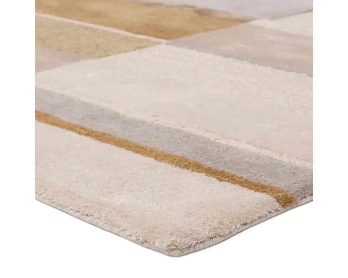 A rectangular area rug featuring a geometric pattern with beige, gray, and yellow colors.