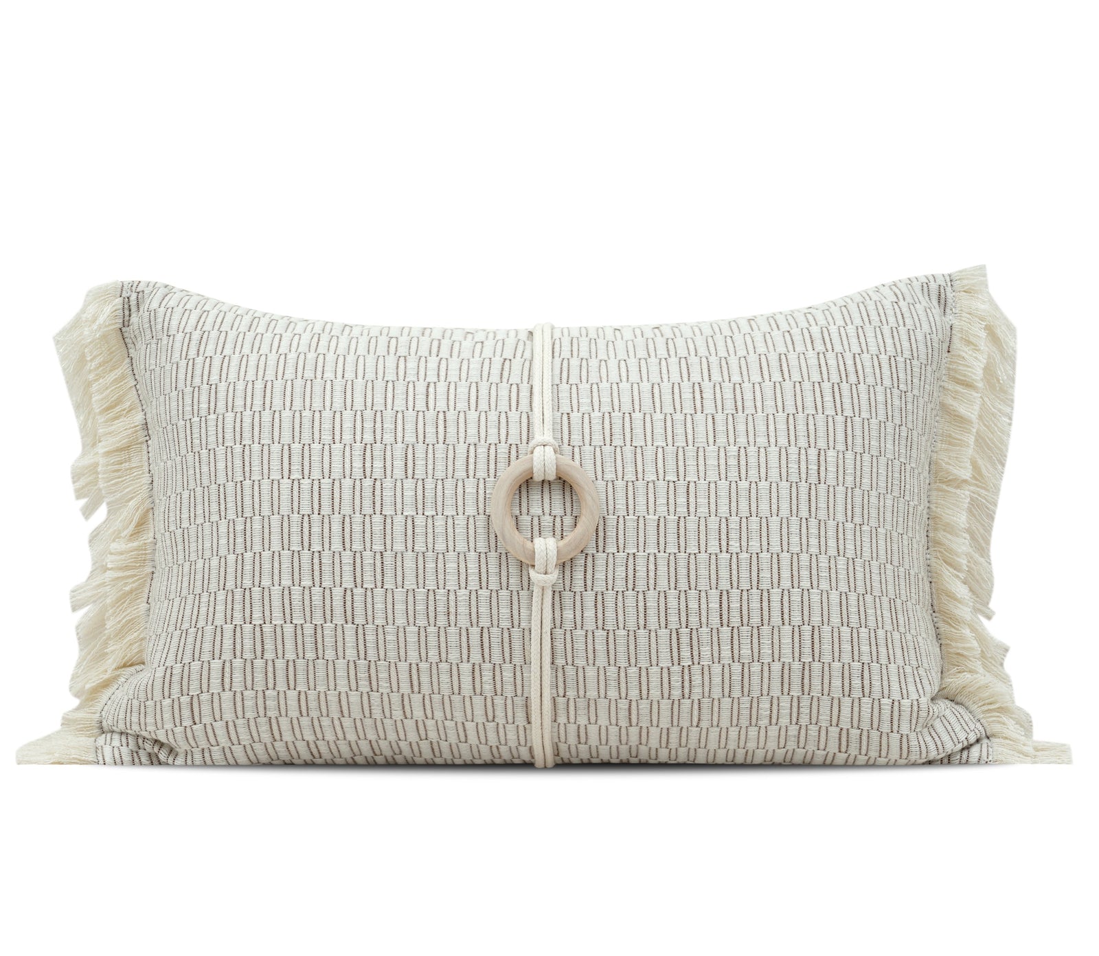 A rectangular woven throw pillow in cream and beige with fringe trim on the sides and a central rope detail with a wooden ring, shown on a white background