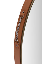 A round accent mirror with a metallic frame and a simple, elegant design.