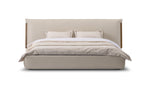 Beige upholstered bed with white bedding on a white background