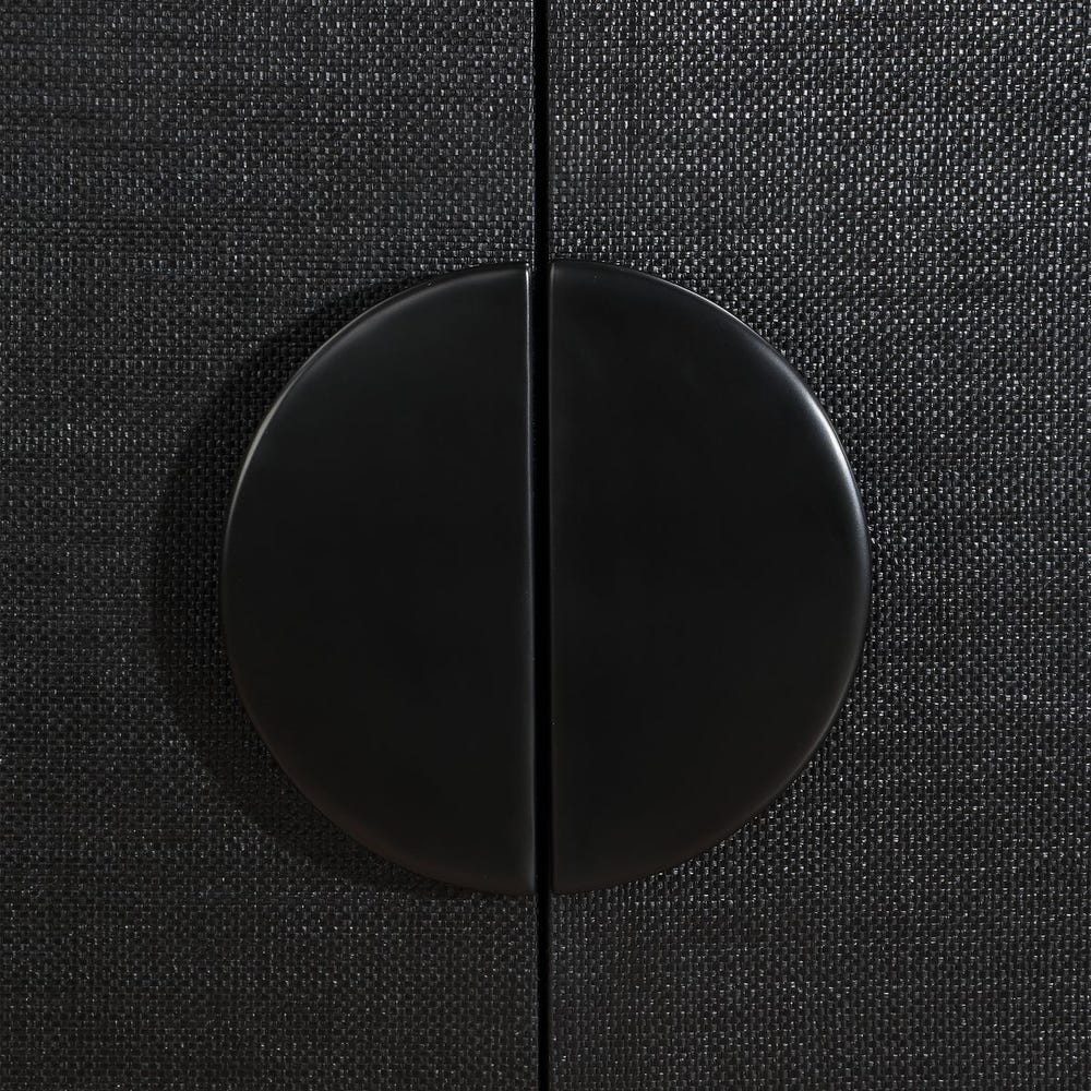 Close-up of a black cabinet knob on a textured black surface