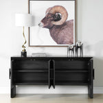 Black console table with decorative items and a framed animal print on a white wall.