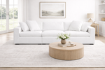 White sofa in a living room with a round wooden coffee table and decorative items.