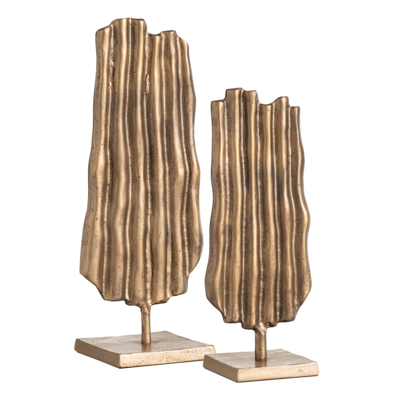 two gold sculptures on a white background