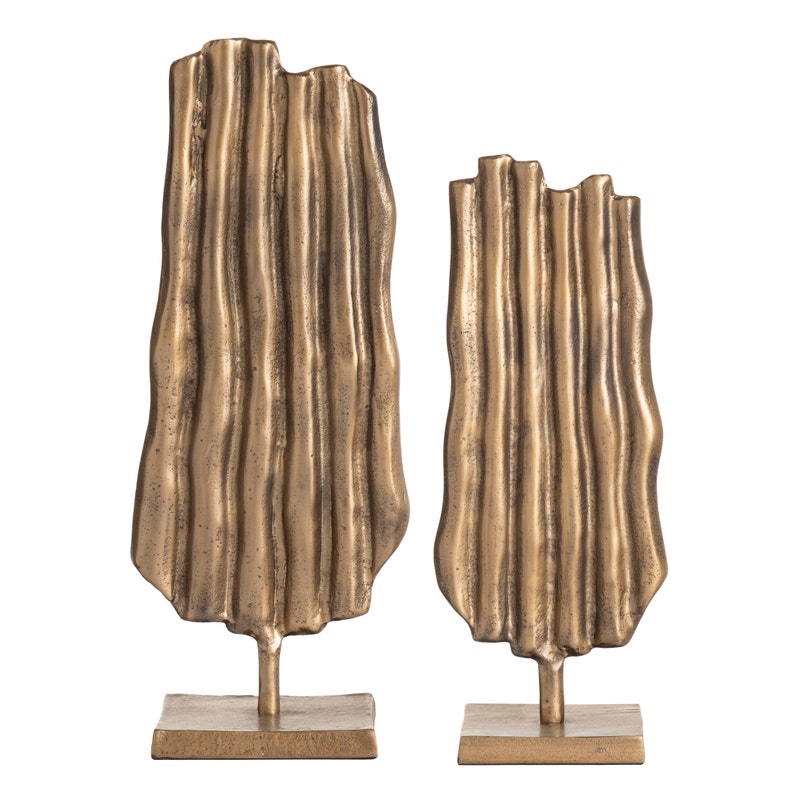 two gold sculptures on a white background