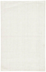 An ivory-colored area rug with a textured weave, partially showing its thickness and material.