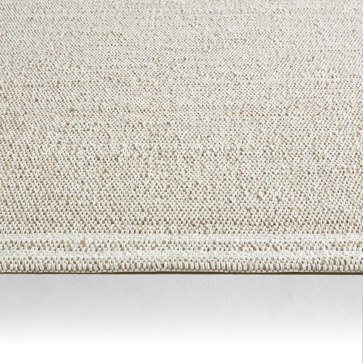 Textured beige rug on a white background