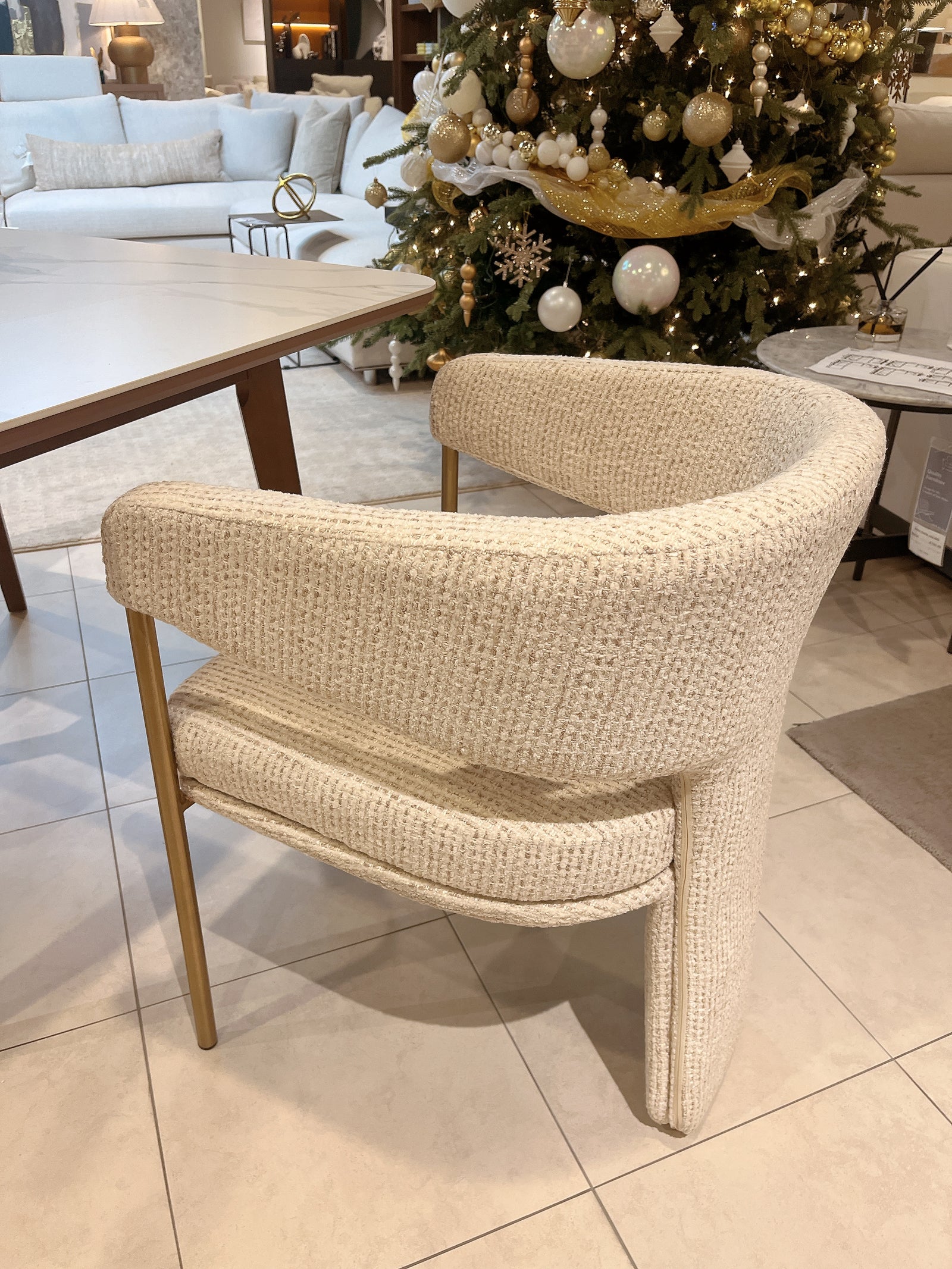 Beige wicker chair in a room with a decorated Christmas tree and furniture.
