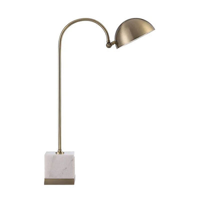 A table lamp with a brass finish and marble base, with an arched metal shade.