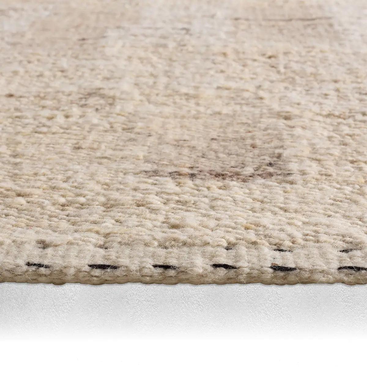 Close-up of a textured beige rug on a white background