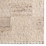 Close-up of a textured beige rug with subtle patterns