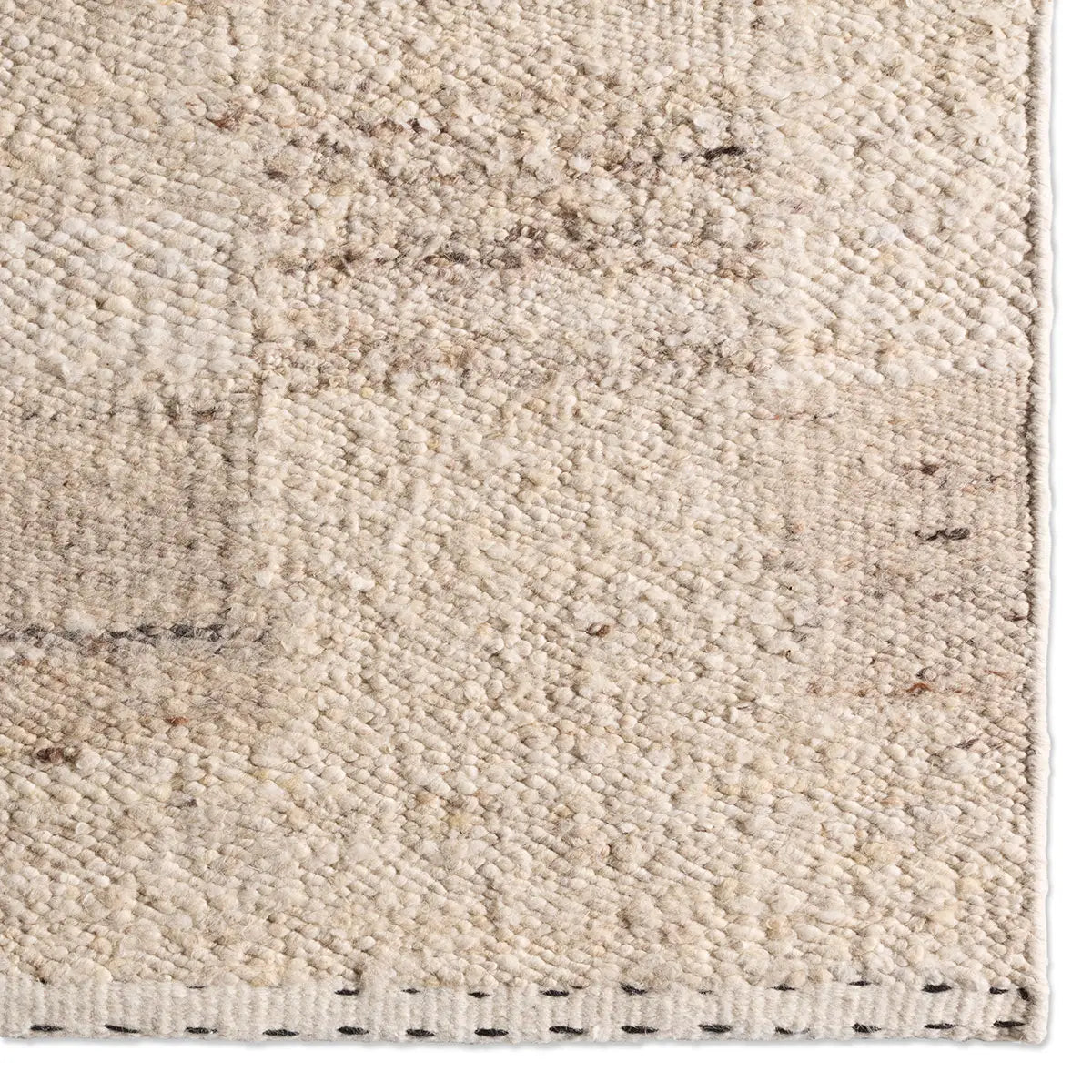 Close-up of a textured beige rug with subtle patterns