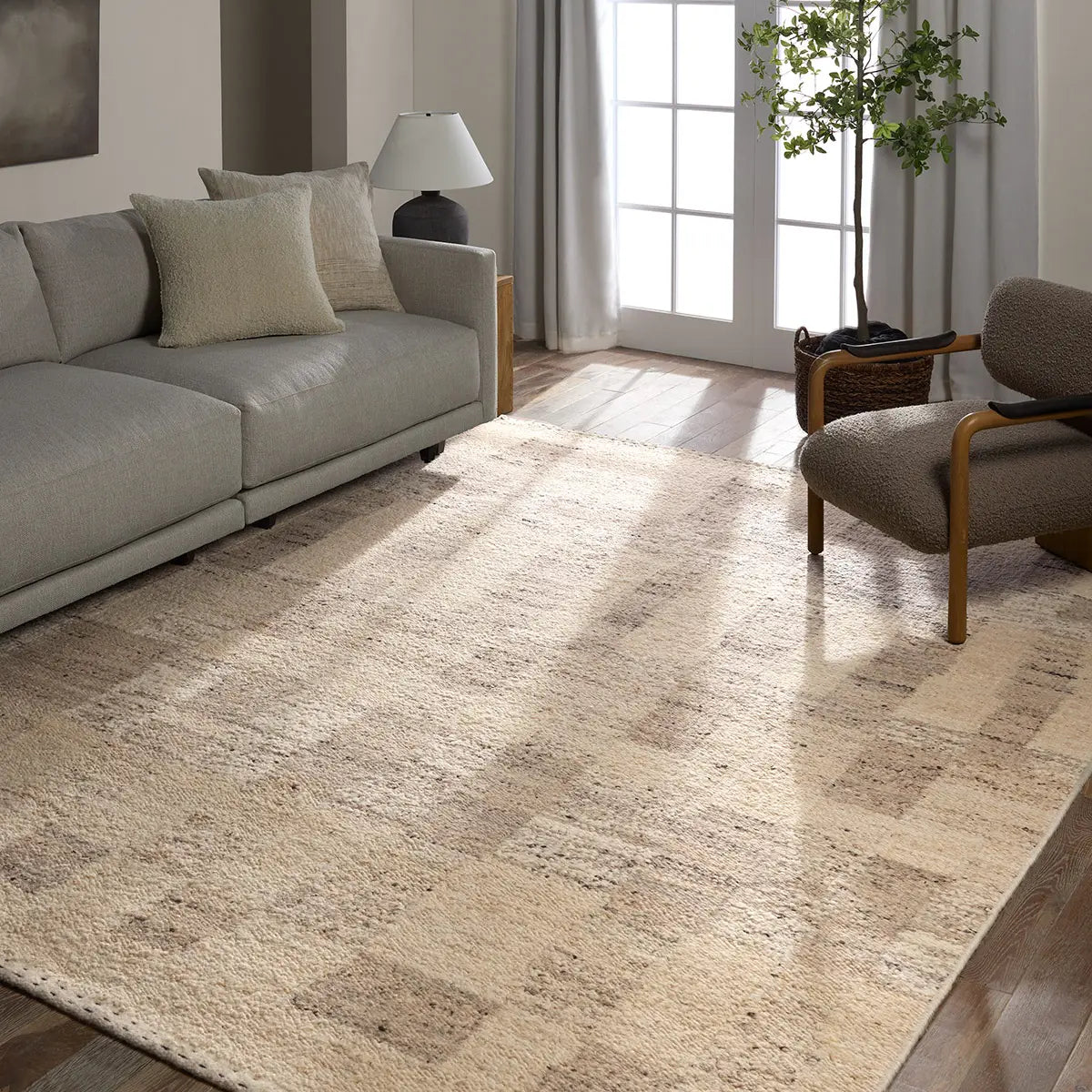 Living room with a textured area rug, gray sofa, and armchair.