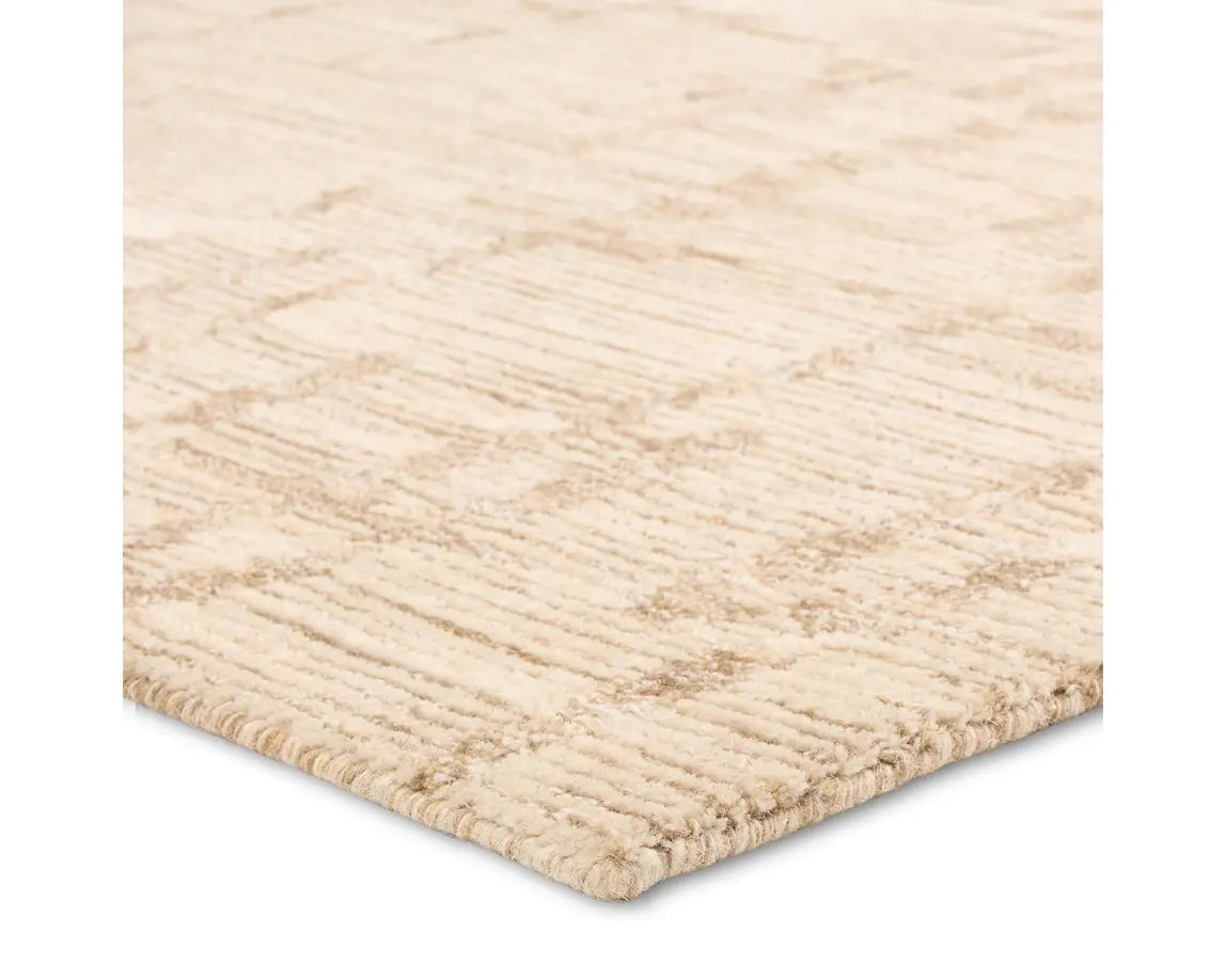 A beige wool area rug with a hand-tufted texture.