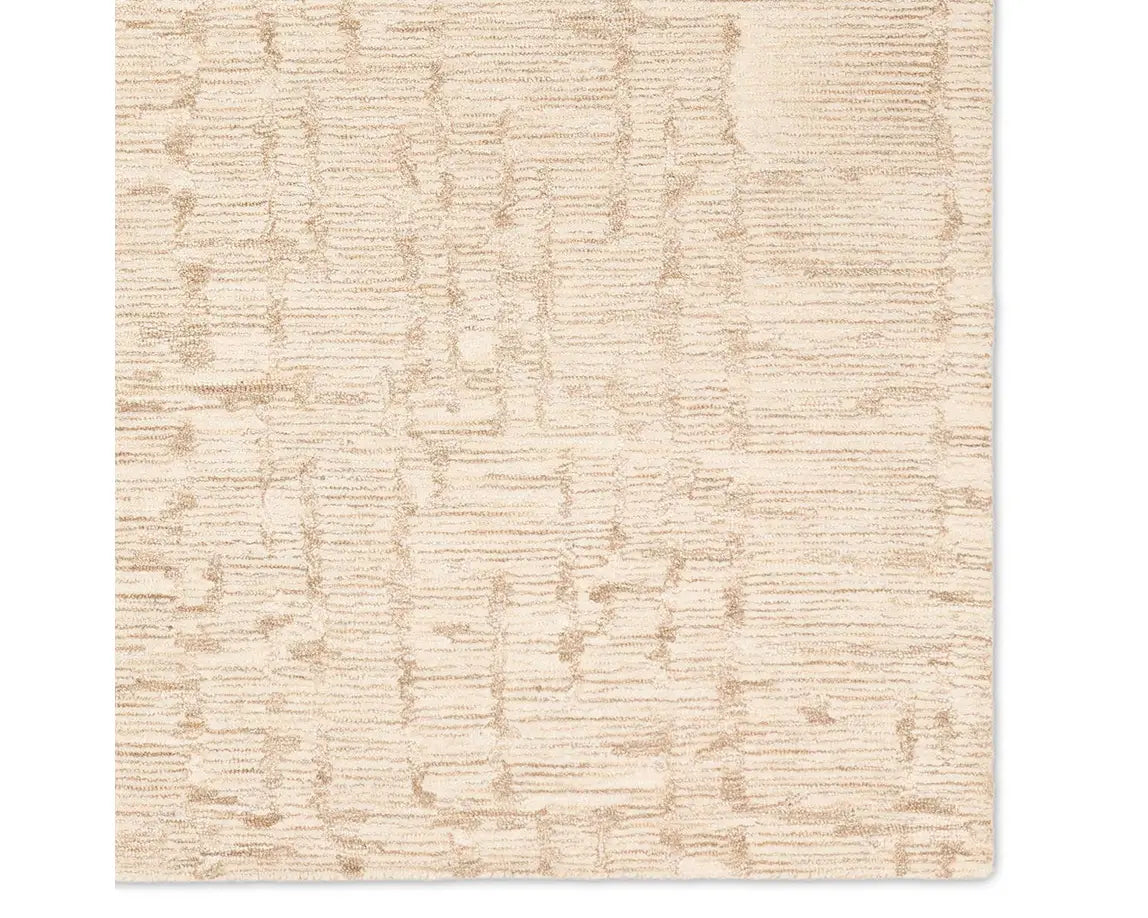 A beige wool area rug with a hand-tufted texture.