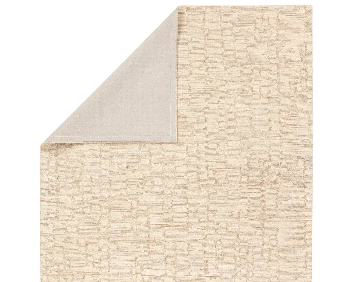 A beige wool area rug with a hand-tufted texture.