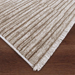 Beige textured rug with fringes on a wooden floor