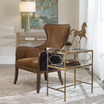 Brown leather armchair in a stylish room with a table and decorative elements.