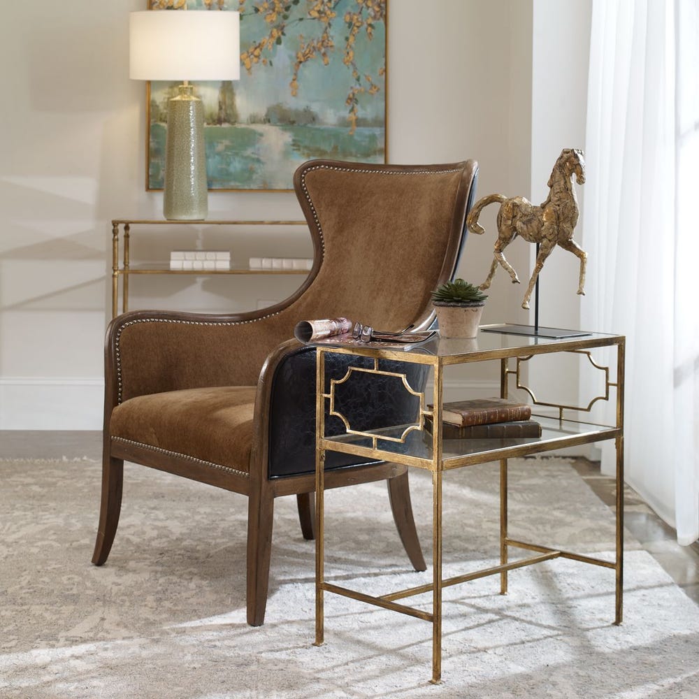 Brown leather armchair in a stylish room with a table and decorative elements.