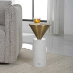 Modern side table with gold cone top and marble base next to a gray sofa in a living room.
