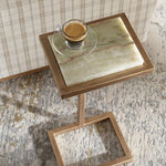 Small side table with marble top and wooden frame, featuring a glass of coffee.
