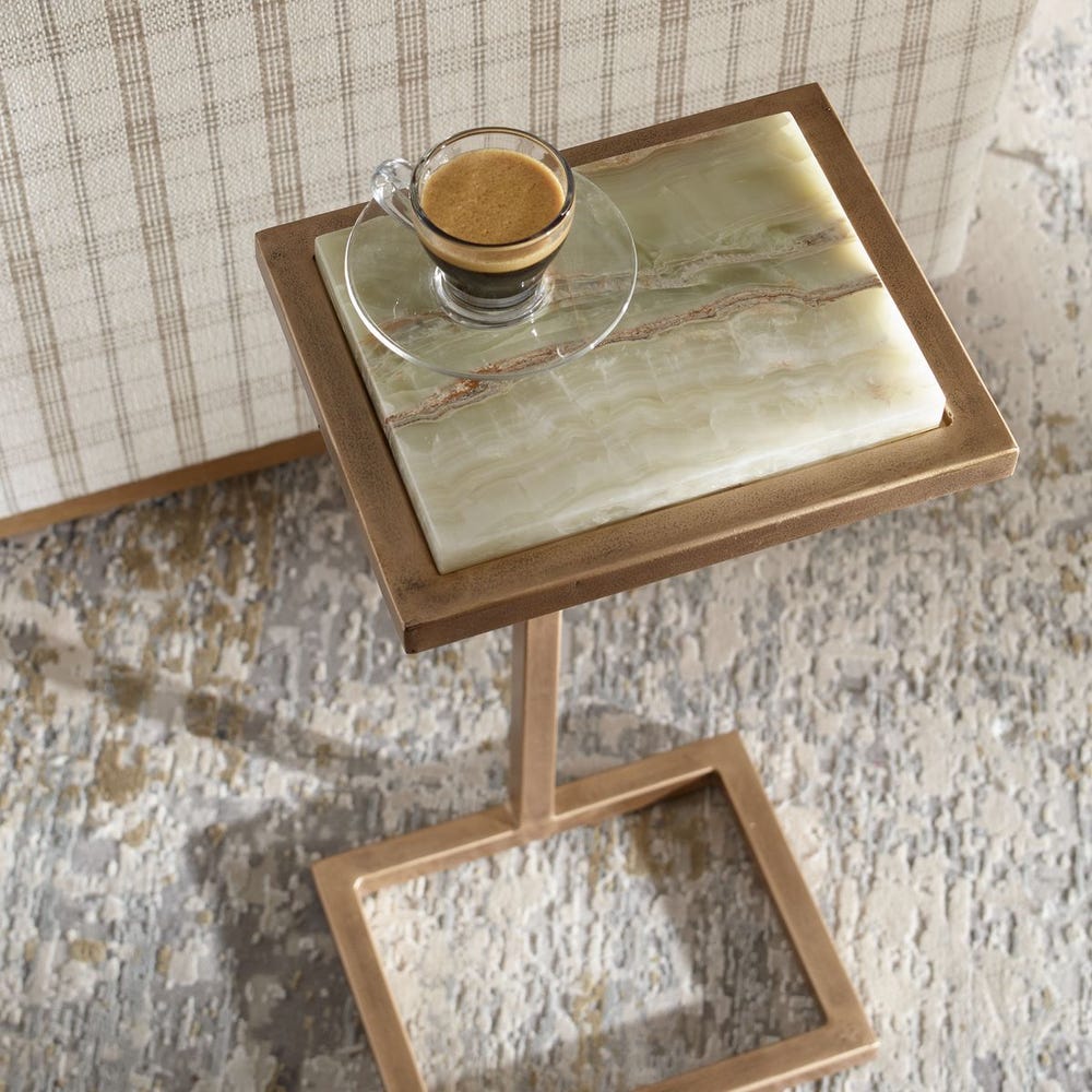 Small side table with marble top and wooden frame, featuring a glass of coffee.