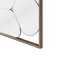 Close-up of a modern wall mirror with a gold frame on a white background