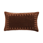 Brown decorative pillow with intricate patterns on a white background