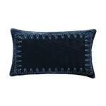 Navy blue decorative pillow with intricate patterns on a white background