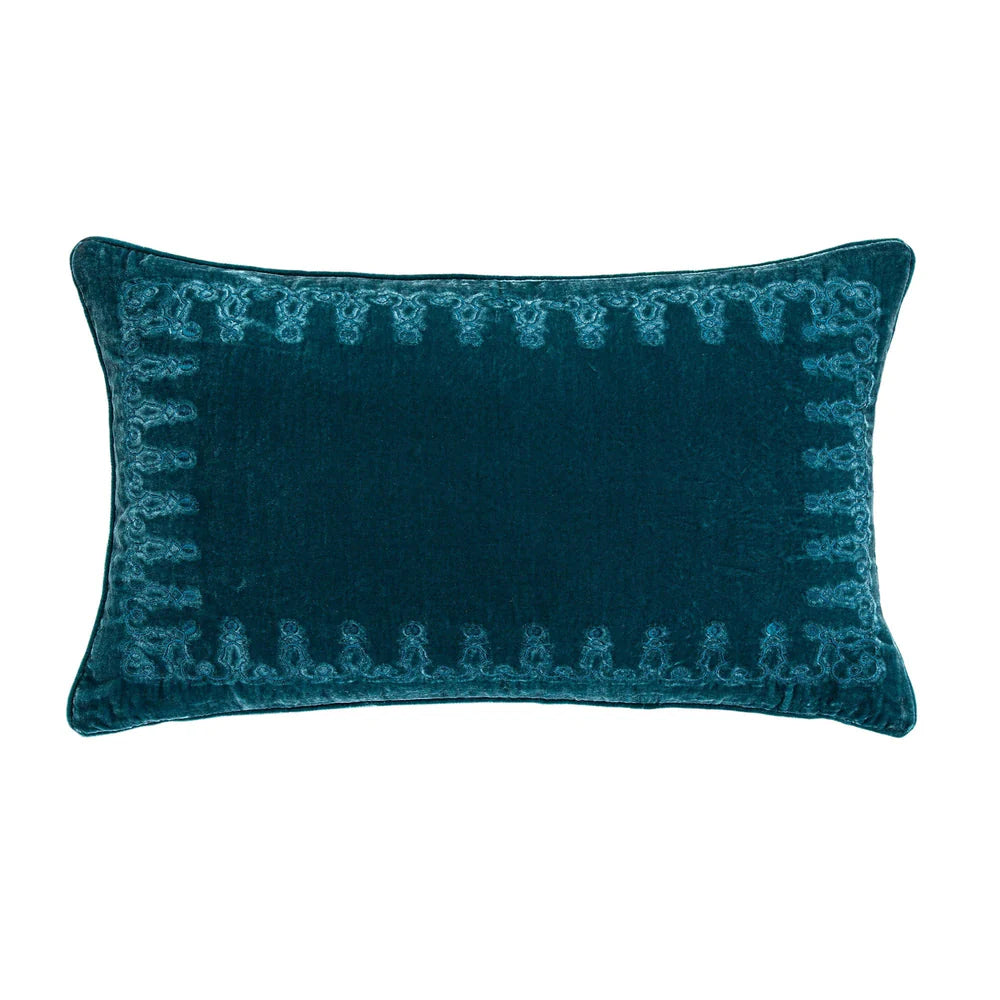 Teal decorative pillow with intricate pattern on a white background
