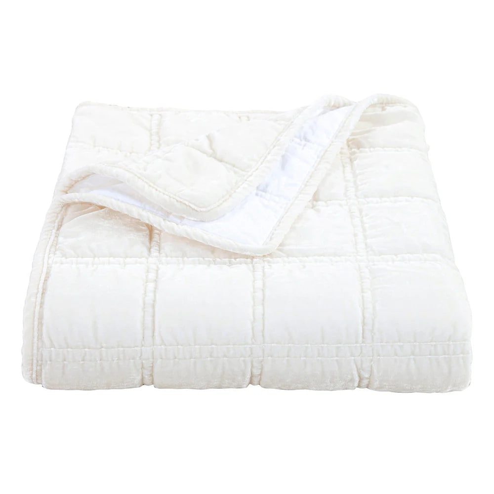 White quilted comforter on a white background