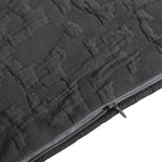 Close-up of a textured black bag with a zipper on a white background