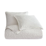 White textured comforter and pillow on a white background