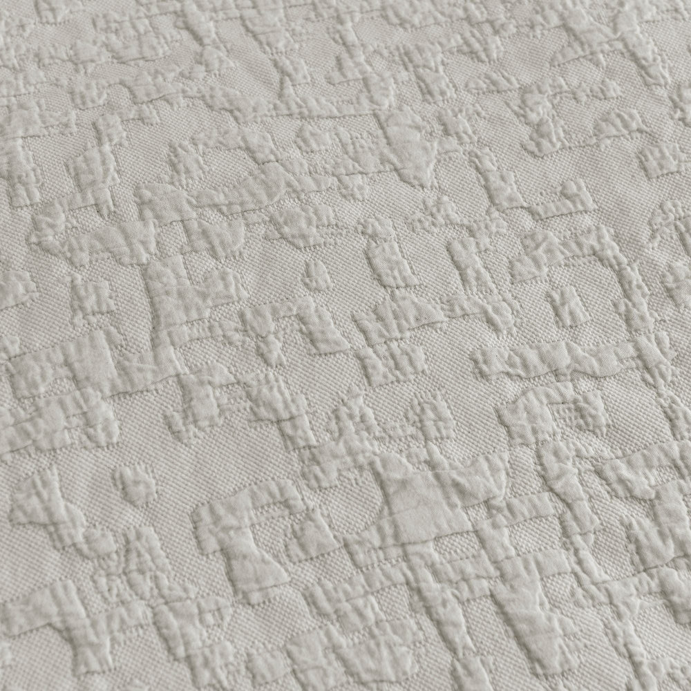 Close-up of textured light gray fabric with a subtle pattern