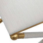 White cushion with gold trim on a chair