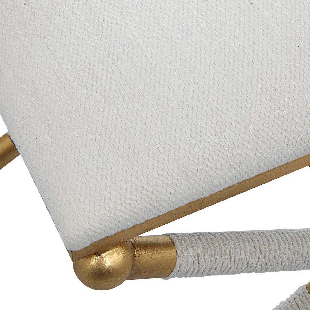 White cushion with gold trim on a chair