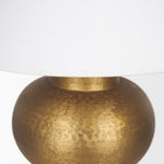 Gold table lamp with a white shade on a white background