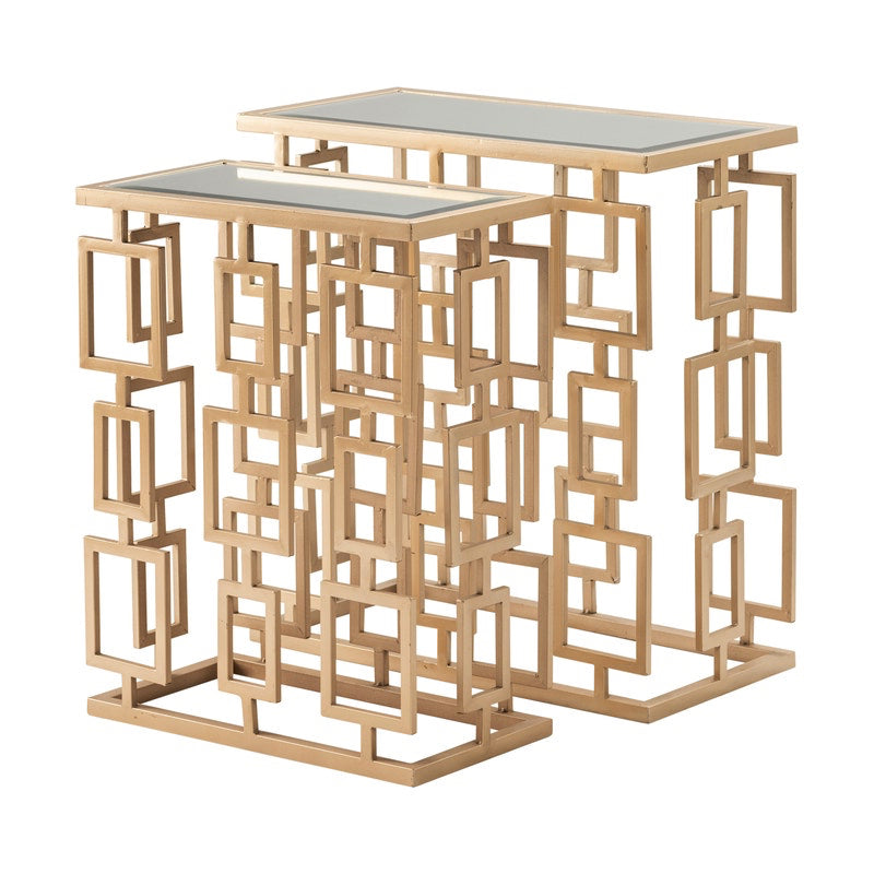 Two rectangular nesting tables with a gold geometric frame design and glass tops.