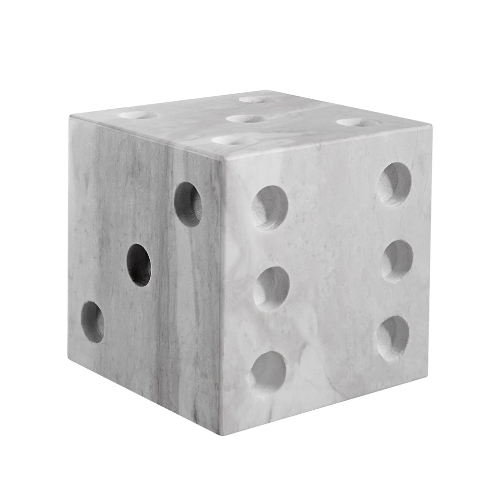 A gray marble dice decor object with multiple holes on each face, resembling dice numbers.