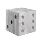 A gray marble dice decor object with multiple holes on each face, resembling dice numbers.