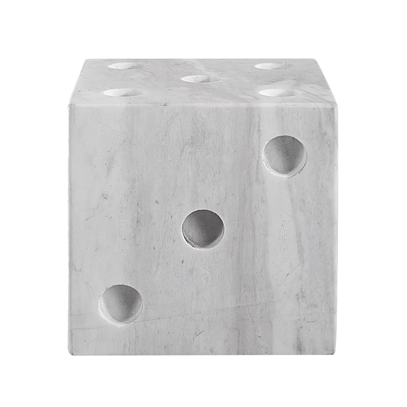 close-up to a gray marble dice decor object with multiple holes on each face, resembling dice numbers.