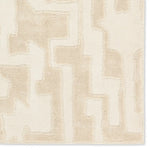 Beige and white geometric patterned rug on a plain background