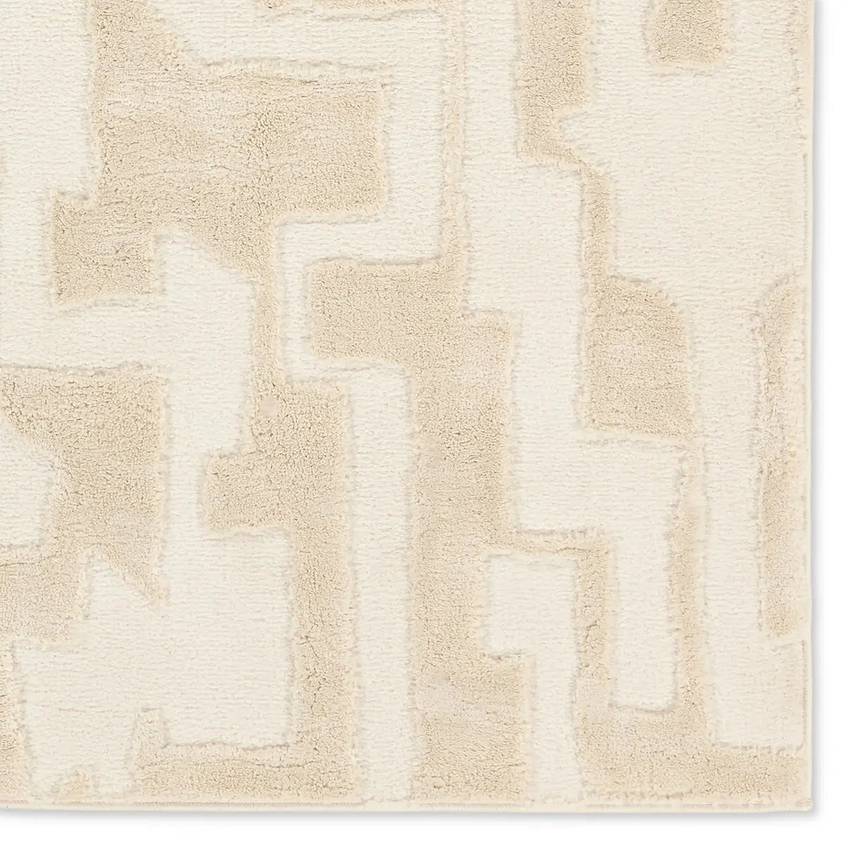 Beige and white geometric patterned rug on a plain background