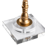 A brass table lamp with a white shade, featuring a twisted stem design on a crystal base.